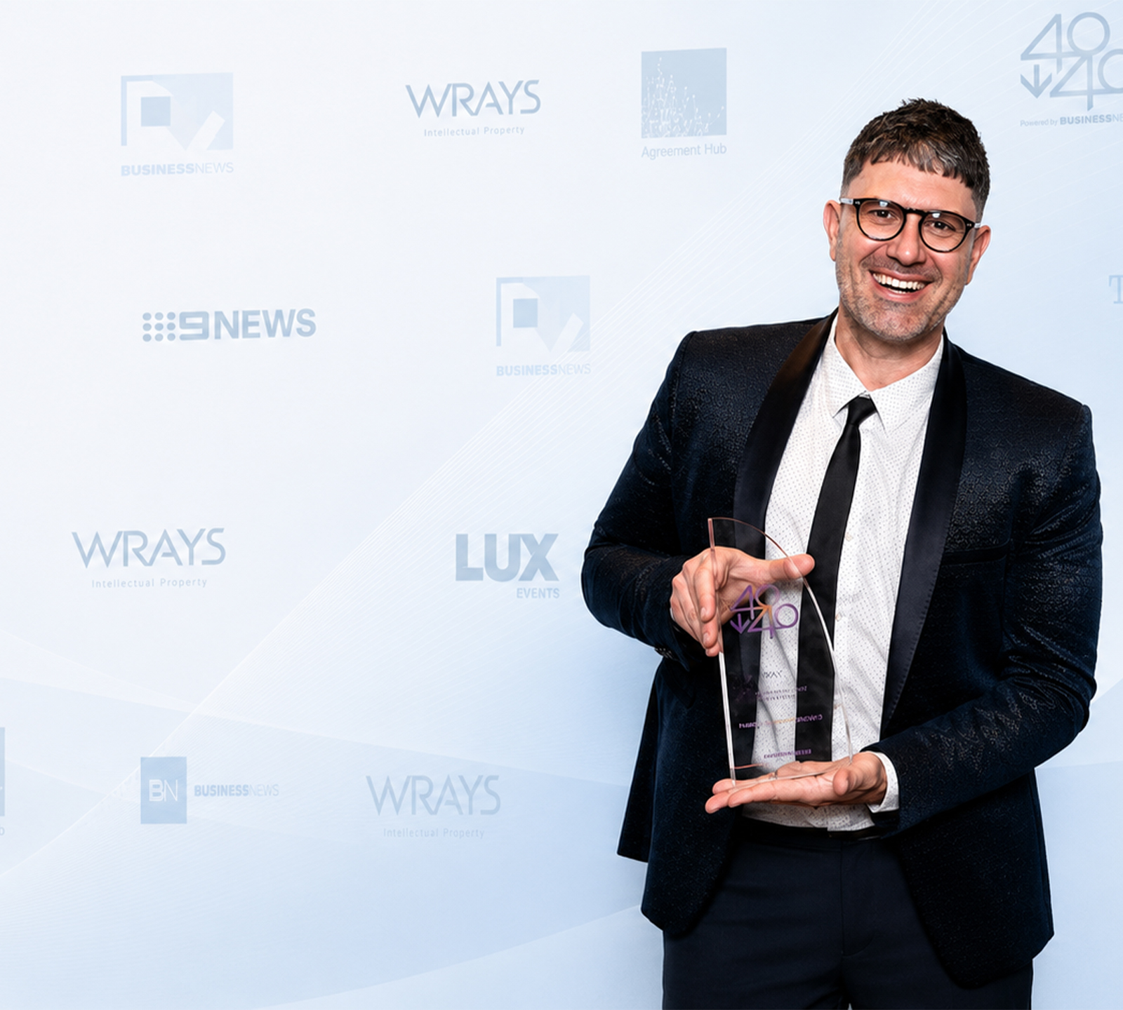 Eli Barlow holding a 40under40 award